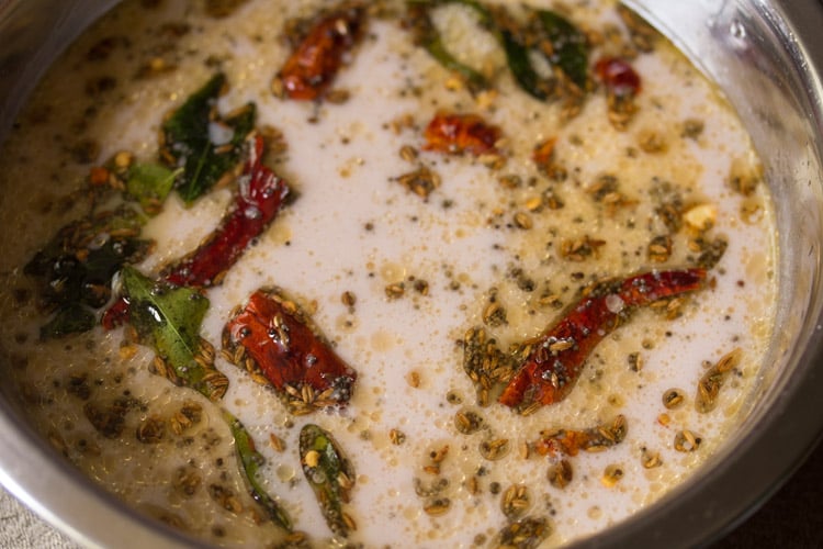 tempered spices with oil floating in the sol kadhi in the bowl.