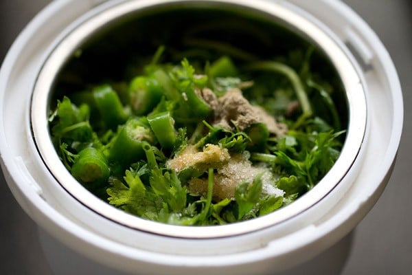 making coriander chutney for bombay sandwich in a grinder jar.