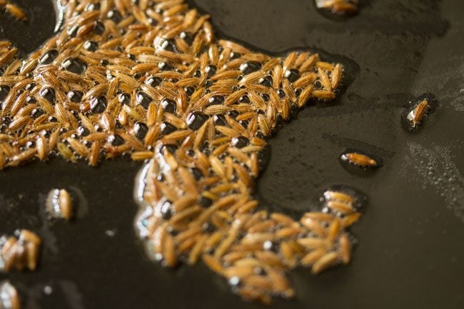 sauteing cumin in oil in kadai