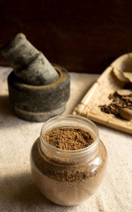 punjabi garam masala in a jar on a linen colored table.