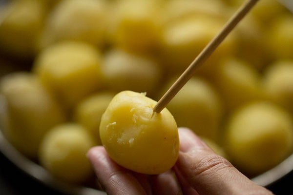 poking boiled potatoes with a skewer.