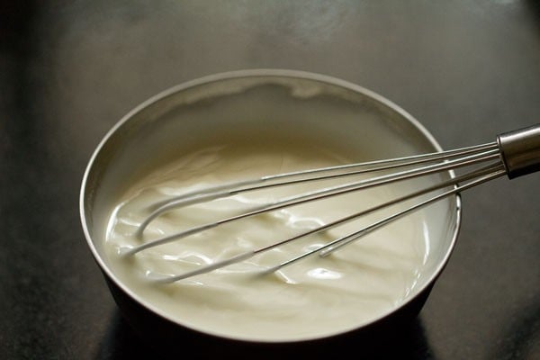 whisking curd in a bowl.