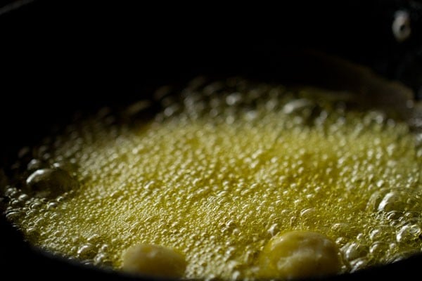 frying boiled potatoes in hot mustard oil in a pan.