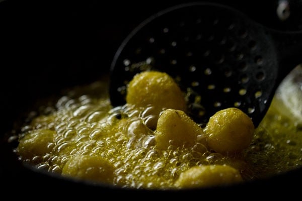 frying boiled potatoes in hot mustard oil in a pan.