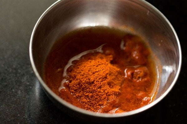 kashmiri red chili powder and water added in a bowl.