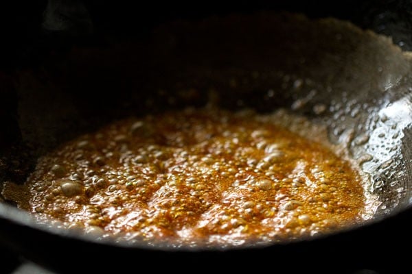 prepared red chili powder-water solution added to pan.
