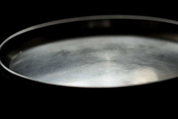 cooking kashmiri dum aloo in covered pan on dum.
