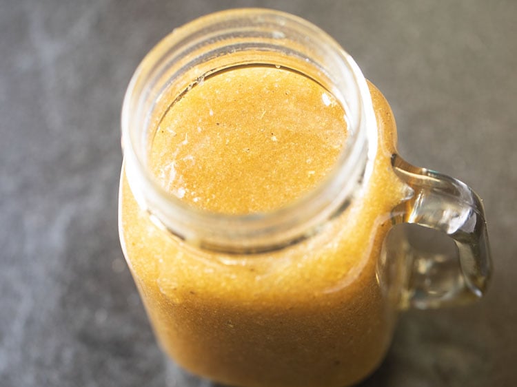 aam ka panna concentrate in a glass jar with a handle.
