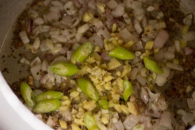 adding ginger, garlic and green chillies for making aloo puri sabzi recipe.