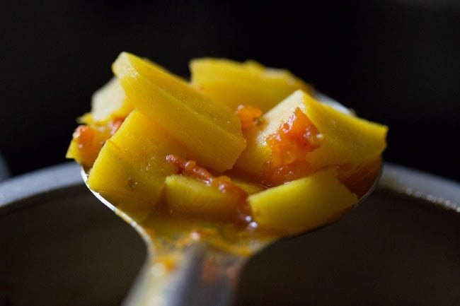 spoon showing consistency of potatoes for aloo poori recipe. 