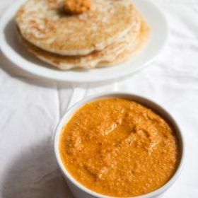 sesame chutney served in a white bowl with dosa