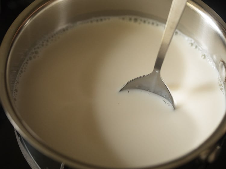 stirring the milk being heated in the pan. 