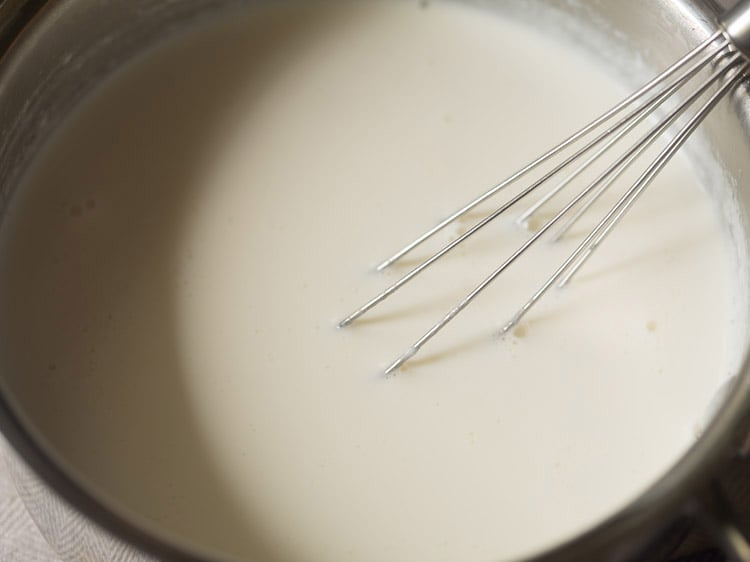 mixing curd starter with milk for dahi recipe.. 