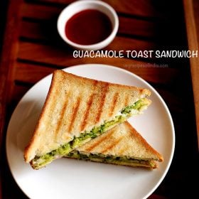 avocado sandwich served on a plate with a side of tomato sauce and text layover.