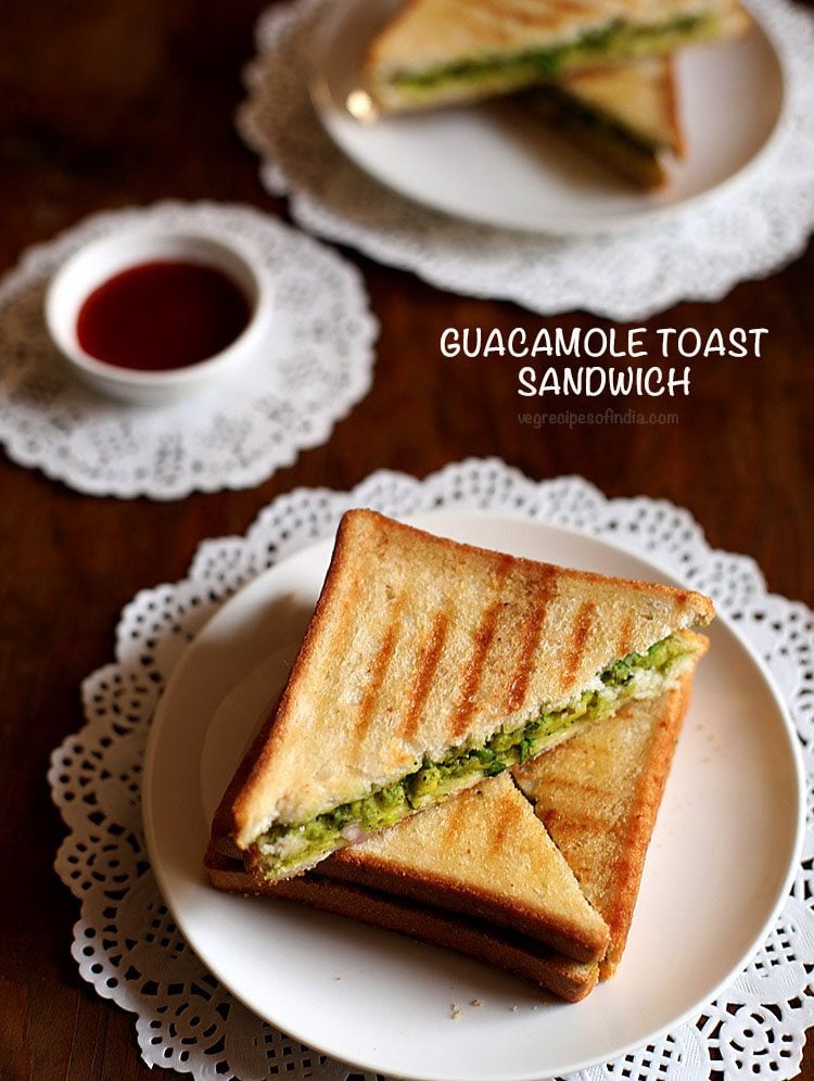 avocado sandwich served on a plate with a side of tomato sauce