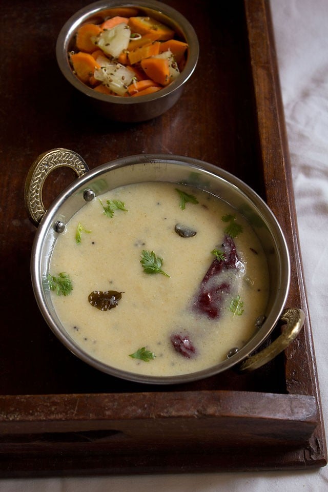 gujarati kadhi garnished with coriander leaves and served with basmati rice and salad.