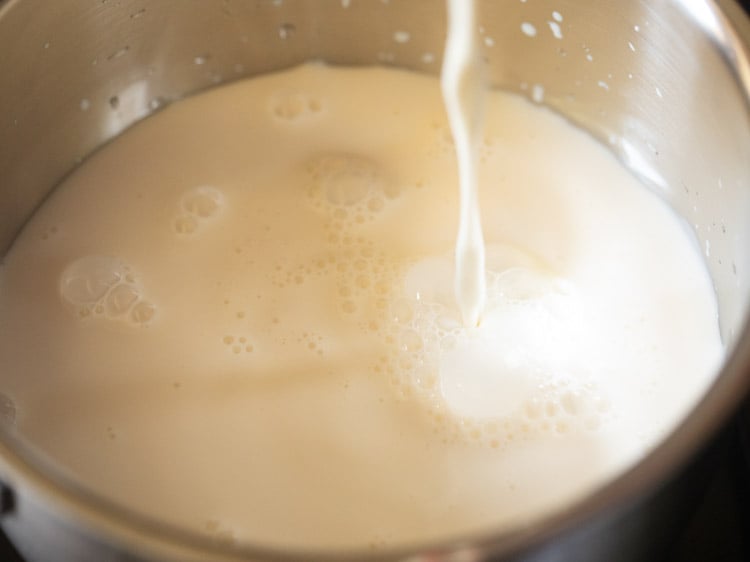 pouring milk in a steel saucepan