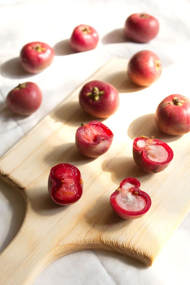 whole fresh kokum fruits and halved kokum fruits