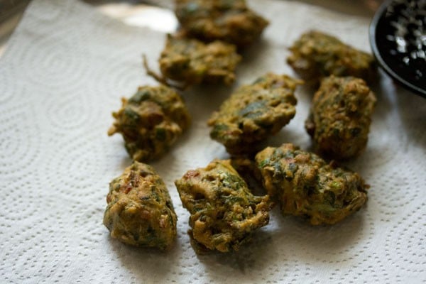 palak pakoda placed on kitchen paper towels