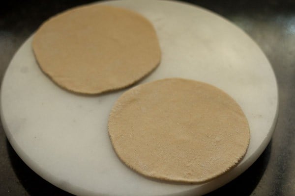 rolling paneer paratha on a board