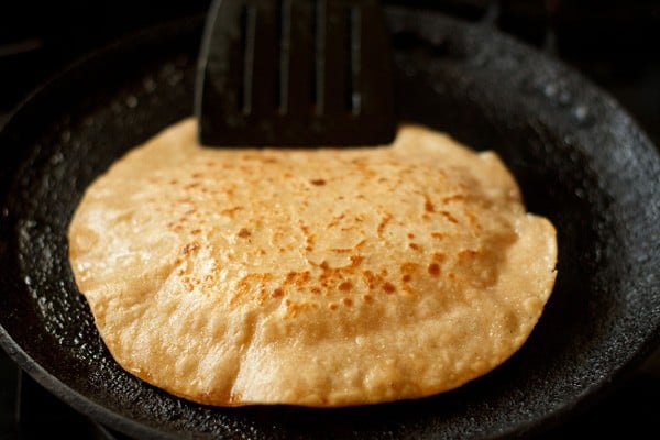 Pressing the edges of paratha with a spatula