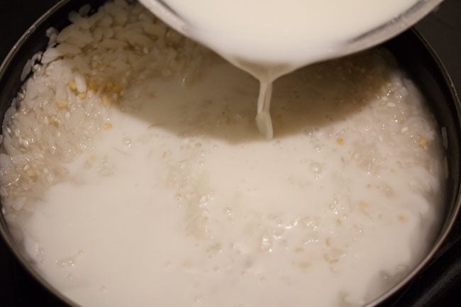 agregando suero de leche al arroz enjuagado poha y urad dal