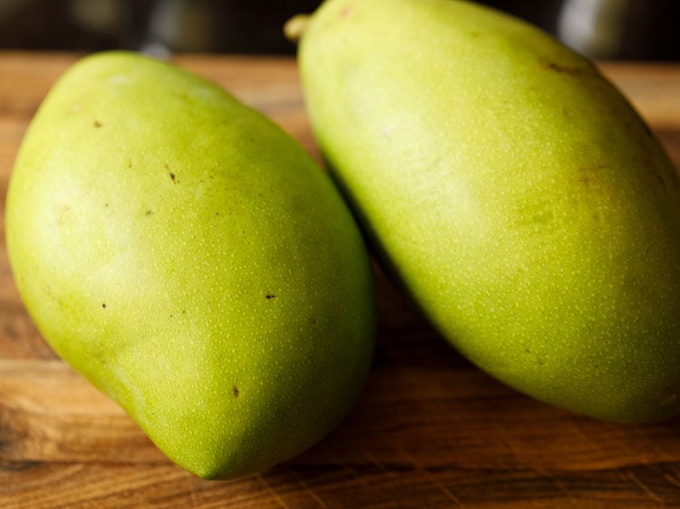 raw mangoes on a chopping board 