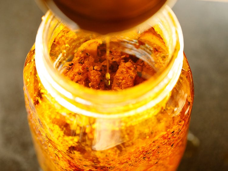 remaining mustard oil being poured in the pickle on the last day 