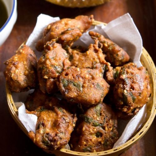 palak pakoda served in a bowl on a wooden board