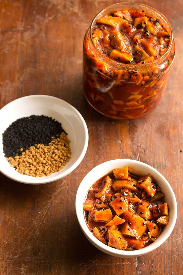 sweet mango pickle served in a bowl with pickle in a jar at the background and spices in a bowl 