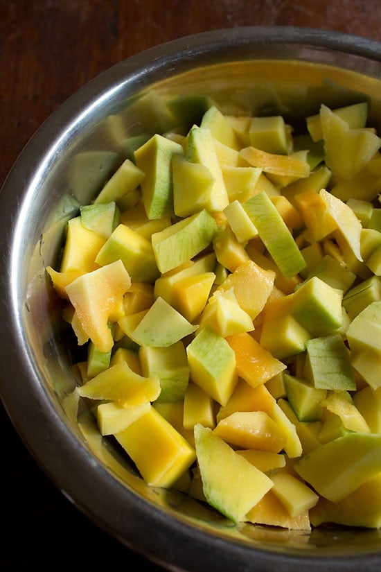 chopped raw mango in a steel bowl to make meetha aam ka achar