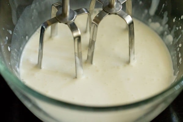 cream being whipped in a glass bowl