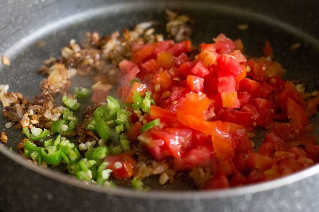 chopped tomatoes and chopped green chili added to pan for making sabut masoor dal. 