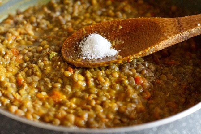 adding salt to red lentils-masala mixture. 