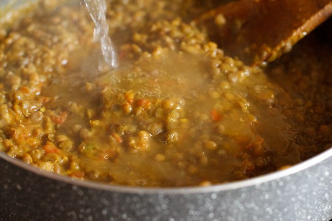 adding water to whole masoor dal and simmering. 