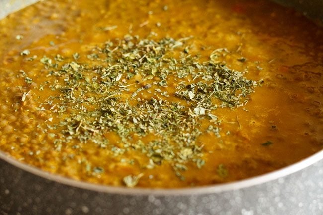 crushed kasuri methi added to cooked whole masoor dal. 