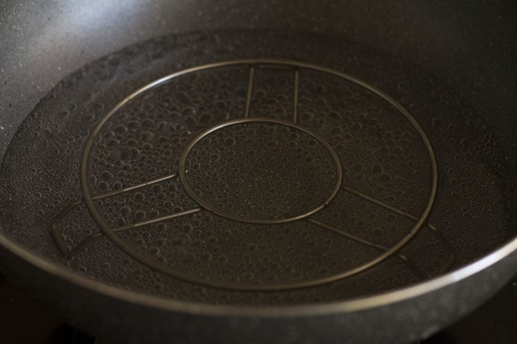 water simmering in a pan with trivet inside