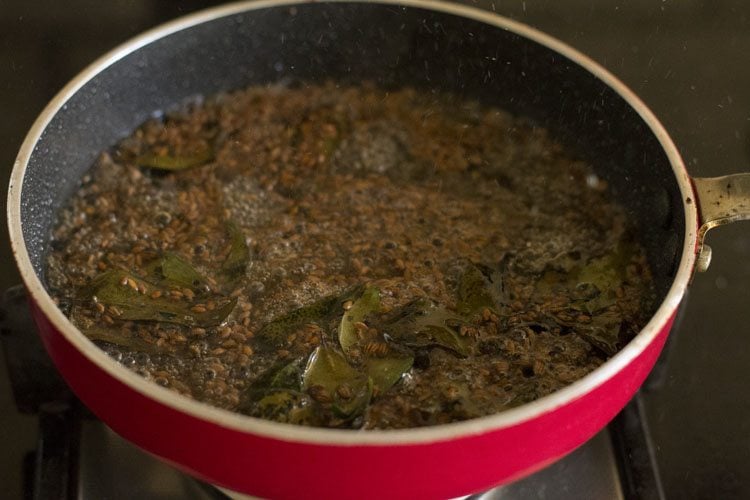 water added to fried tempering ingredients in bowl