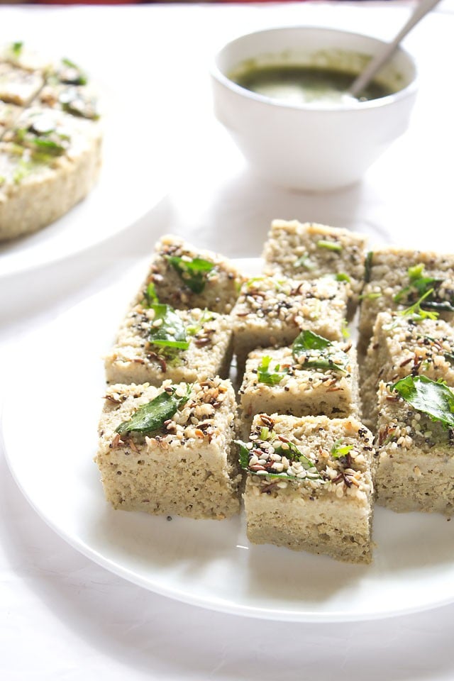 moong dal dhokla squares in a white plate