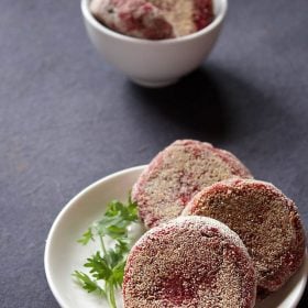 beetroot cutlet served on a white plate with a coriander sprig kept on the side.
