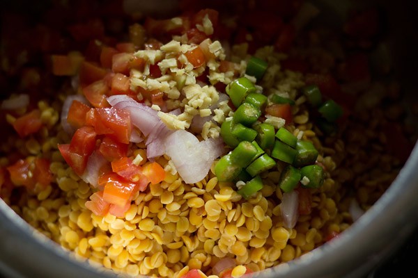 chopped onions, ginger, tomatoes and green chillies added to the lentils in the pressure cooker