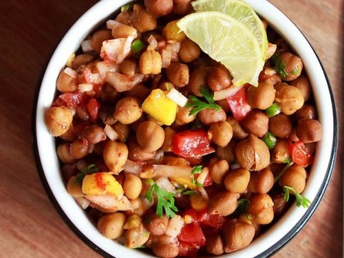 kala chana chaat with lemon wedges in a bowl