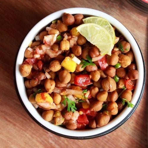 kala chana chaat with lemon wedges in a bowl