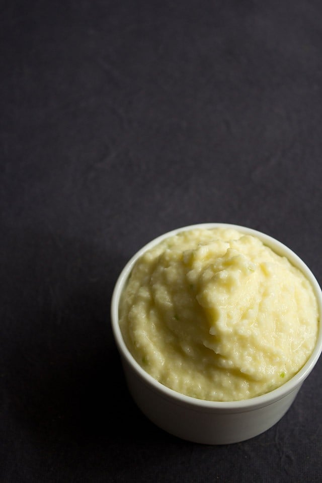 raw mango chutney in white bowl on a black backdrop