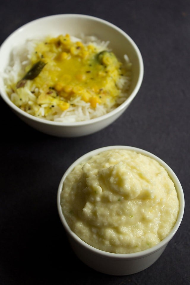 raw mango chutney served in a bowl with dal-rice served in another bowl. 