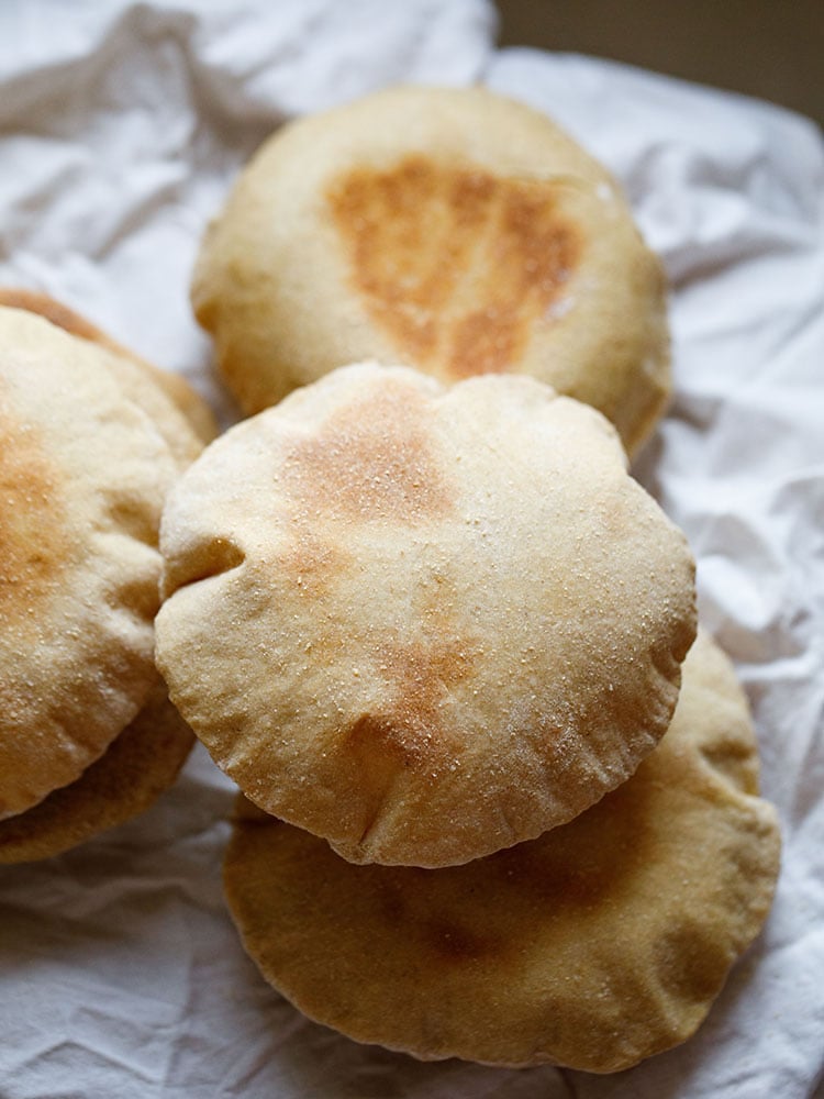 top view of puffed up pita bread placed on white cotton napkin