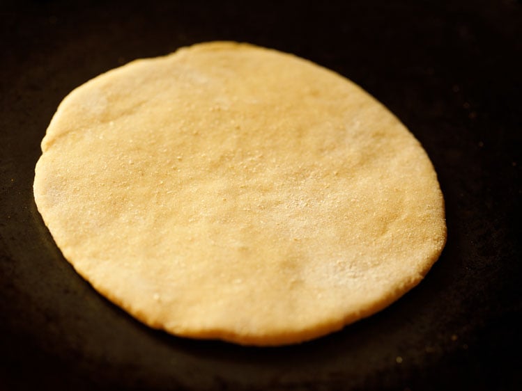 rolled disc placed on a hot skillet