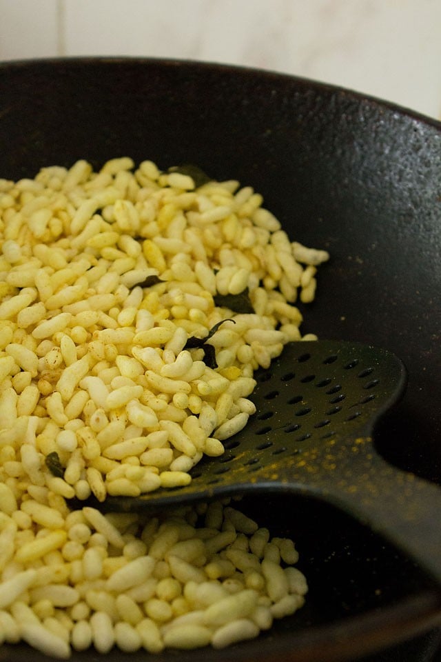 roasting spiced puffed rice in pan. 