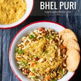 bhel puri served with a side of crisp baked puri in a red rimmed white bowl