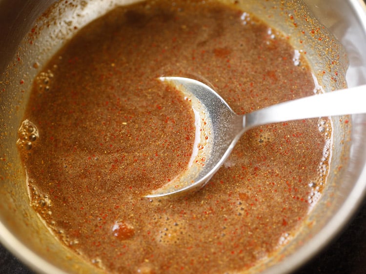spice powders mixed with water with a steel spoon